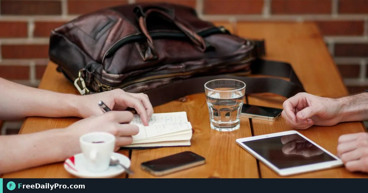 Person converting iPhone HEIC photos to JPG on a laptop beside a phone